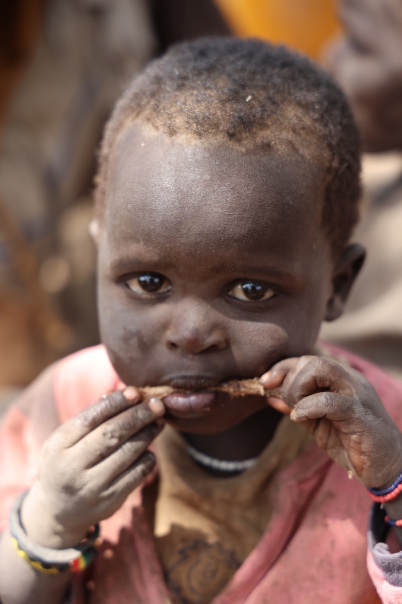 A young child is eating a piece of food